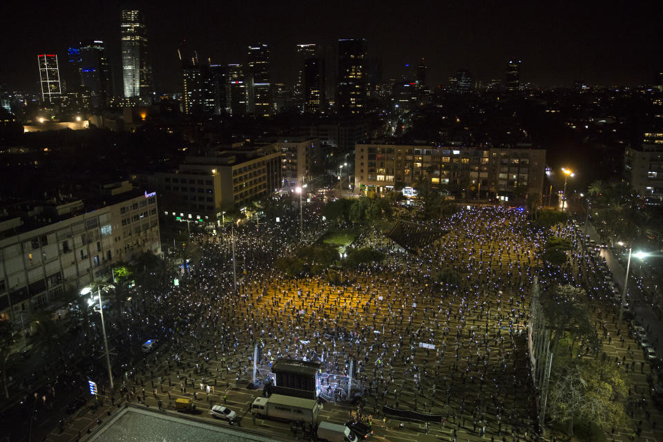 Israelis light flash lights as they protest at a rally in Rabin Square on April 19, 2020 in Tel Aviv, Israel. Thousands of Israelis gather at an Anti-Corruption rally under coronavirus restrictions, decrying proposed unity government talks between Israeli Prime Minister Benjamin Netanyahu, and Blue and White Party leader Benny Gantz. (Photo by /Getty Images) | Amir Levy—Getty Images