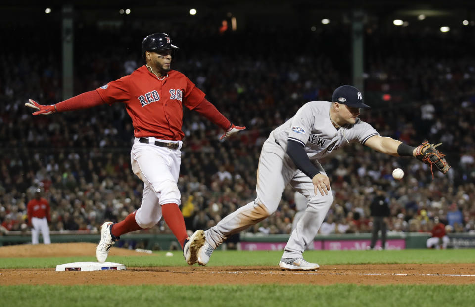 New York Yankees first baseman Luke Voit, right, fails to hang on to the throw after a single by Boston Red Sox's Xander Bogaerts during the fifth inning of Game 1 of a baseball American League Division Series on Friday, Oct. 5, 2018, in Boston. (AP Photo/Charles Krupa)