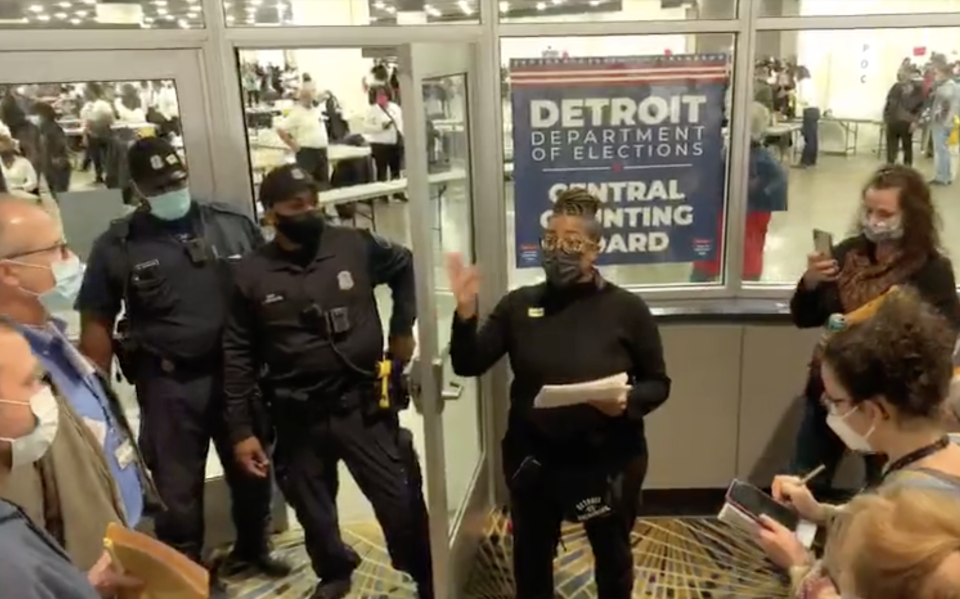 Election worker Sommer Woods speaks to challengers gathered at an entrance to TCF during vote counting in Detroit. 