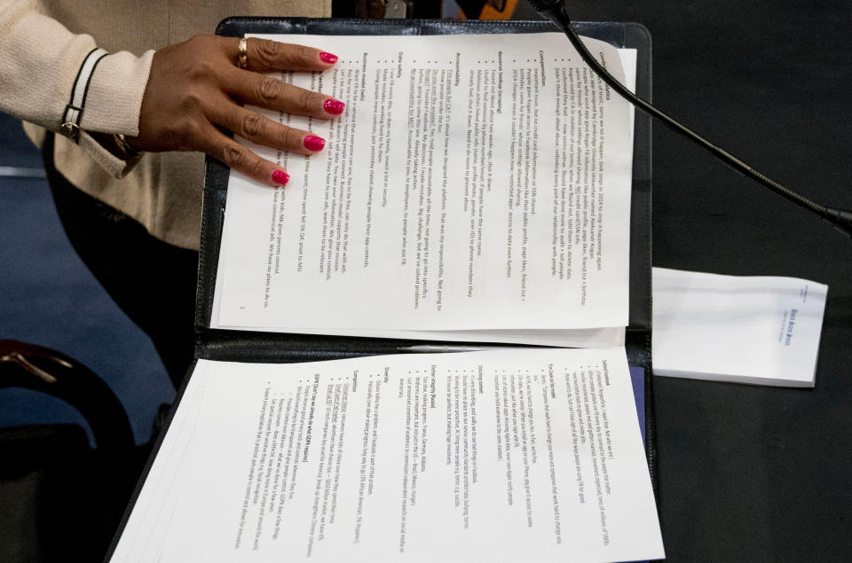 An aide to Facebook CEO Mark Zuckerberg closes a binder of notes left on the table as Zuckerberg takes a short break from testifying. (AP Photo/Andrew Harnik)