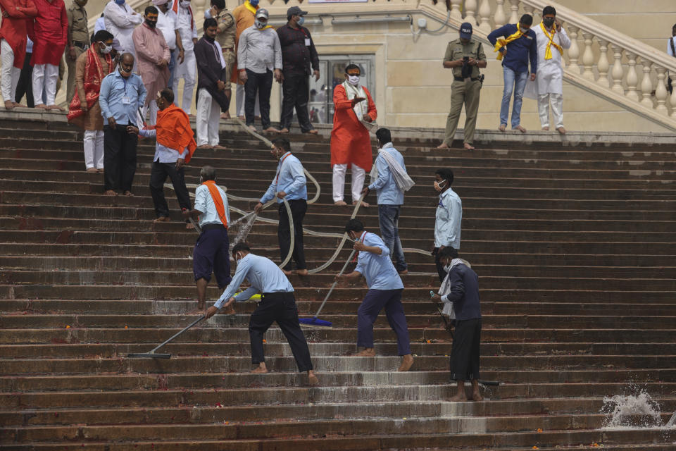 Workers clean the steps as thousands of devotees arrive to take holy dips in the Ganges River during Kumbh Mela, or pitcher festival, one of the most sacred pilgrimages in Hinduism, in Haridwar, northern state of Uttarakhand, India, Monday, April 12, 2021. Tens of thousands of Hindu devotees gathered by the Ganges River for special prayers Monday, many of them flouting social distancing practices as the coronavirus spreads in India with record speed. (AP Photo/Karma Sonam)