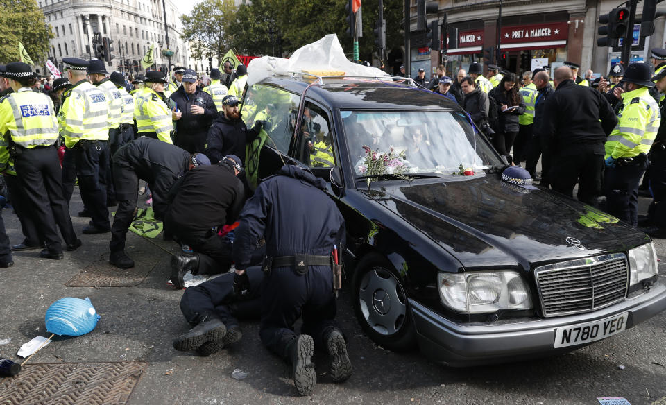 Climate change protesters are removed from a hearse and arrested in Trafalgar Square in London, Thursday, Oct. 10, 2019. Some hundreds of climate change activists are in London during a fourth day of world protests by the Extinction Rebellion movement to demand more urgent actions to counter global warming. (AP Photo/Alastair Grant)