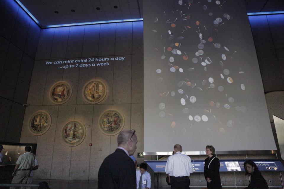 People wait in the lobby of the U.S. Mint to take a tour on Wednesday, June 27, 2012, in Philadelphia. The new $3.9 million exhibit opens a new tour to visitors on July 3 and it's the first upgrade in more than 40 years. (AP Photo/Brynn Anderson)