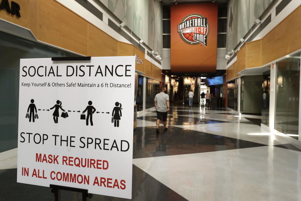 A sign advising safety measures for the coronavirus stands near an entrance to the Naismith Memorial Basketball Hall of Fame, in Springfield, Mass., Tuesday, June 23, 2020. The museum is scheduled to reopen in the beginning of July 2020 with a whole new look after a $22 million renovation. (AP Photo/Steven Senne)