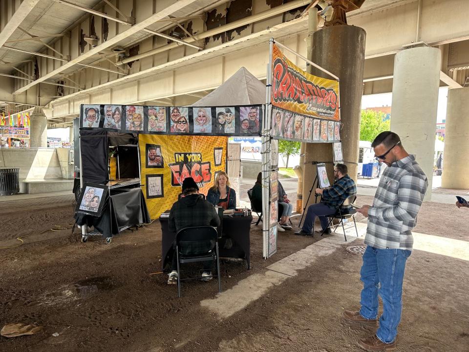 Families sit for caricature drawings under the bridge at Thunder Over Louisville, on Saturday, April 22, 2023.
