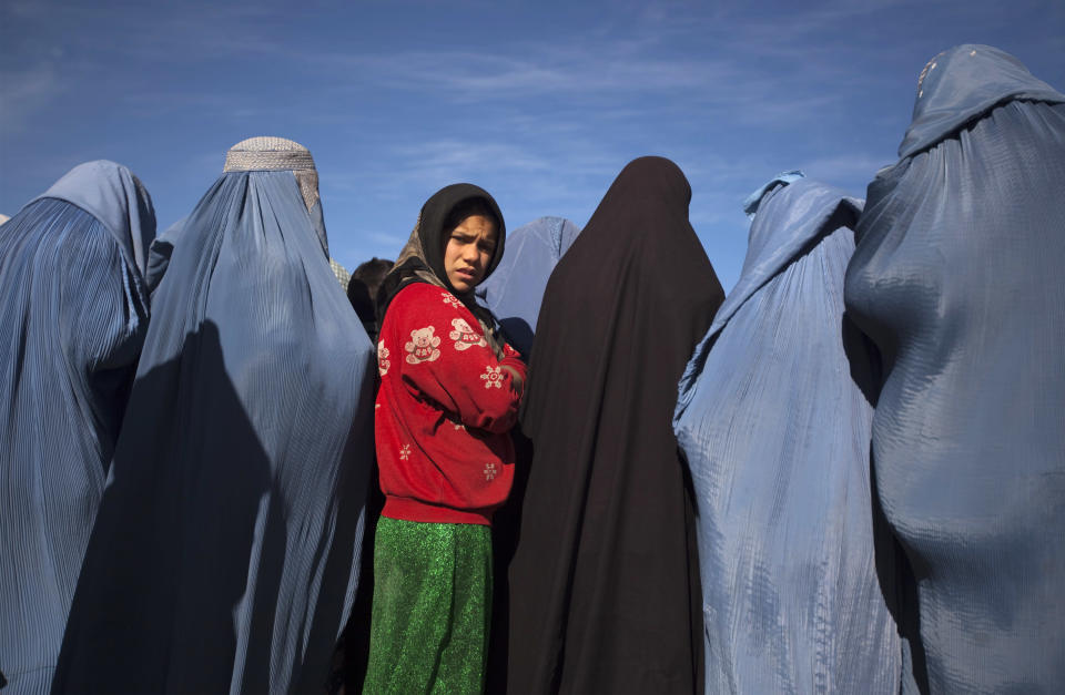 Afghan girl stands among widows clad in burqas during cash for work project by humanitarian organisation CARE International in Kabul