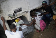 Relatives of Emily Victoria Silva dos Santos, 4, and Rebeca Beatriz Rodrigues dos Santos, 7, mourn during their burial at a cemetery in Duque de Caxias, Rio de Janeiro state, Brazil, Saturday, Dec. 5, 2020. Grieving families held funerals for Emily and Rebeca, killed by bullets while playing outside their homes. Weeping and cries of “justice” were heard Saturday at their funerals, reflecting the families’ assertion that the children were killed by police bullets. (AP Photo/Silvia Izquierdo)