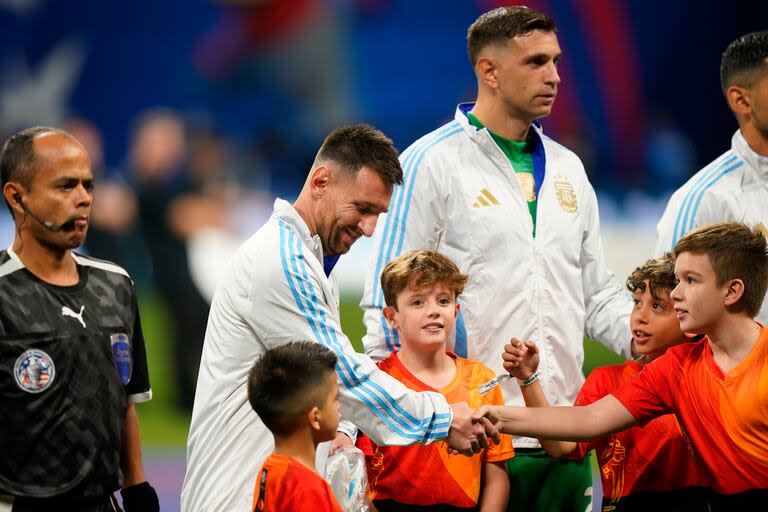 Lionel Messi saluda a los niños voluntarios antes del himno nacional.