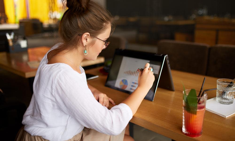 Businesswoman hand pointing with stylus on the chart over convertible laptop screen in tent mode