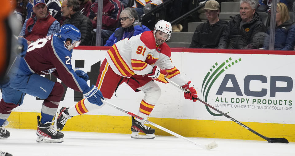 Calgary Flames center Nazem Kadri, right, drives past Colorado Avalanche left wing Miles Wood, left, in the second period of an NHL hockey game Monday, Dec. 11, 2023, in Denver. (AP Photo/David Zalubowski)