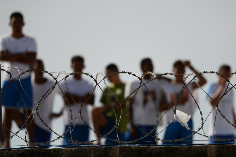 Inmates watch as injured prisoners are removed for medical care after fighting broke out between two gangs in the Alcacuz Penitentiary in Rio Grande do Norte state in January 2017