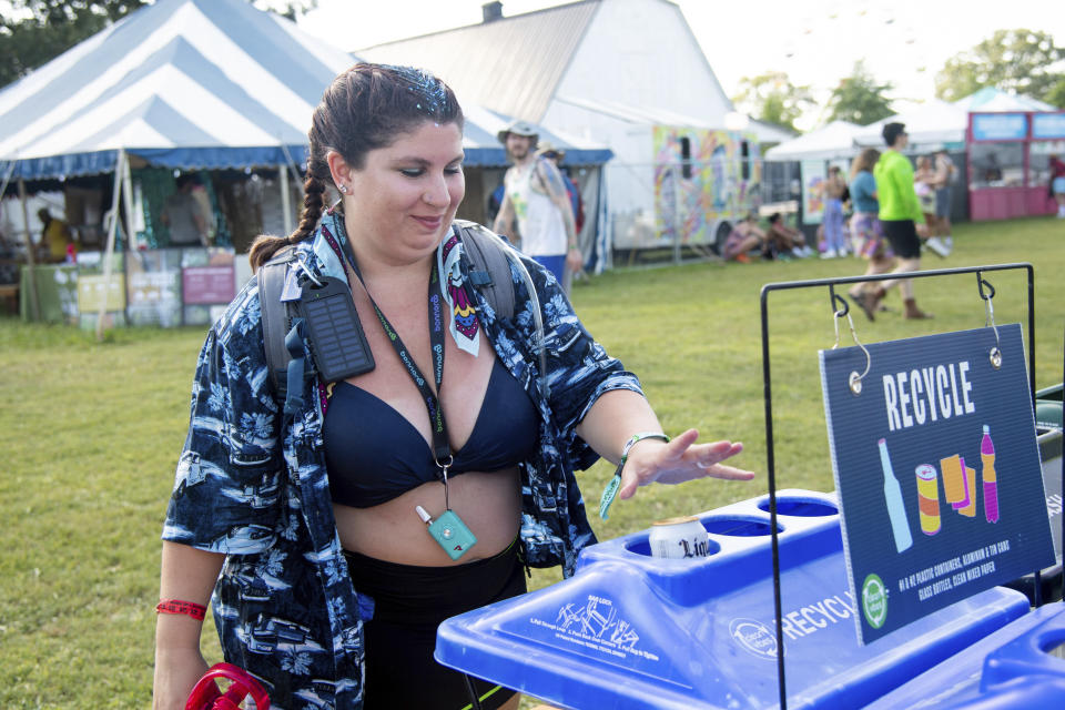 A festivalgoers is seen using a recycling station at the Bonnaroo Music and Arts Festival on Thursday, June 16, 2022, in Manchester, Tenn. (Photo by Amy Harris/Invision/AP)