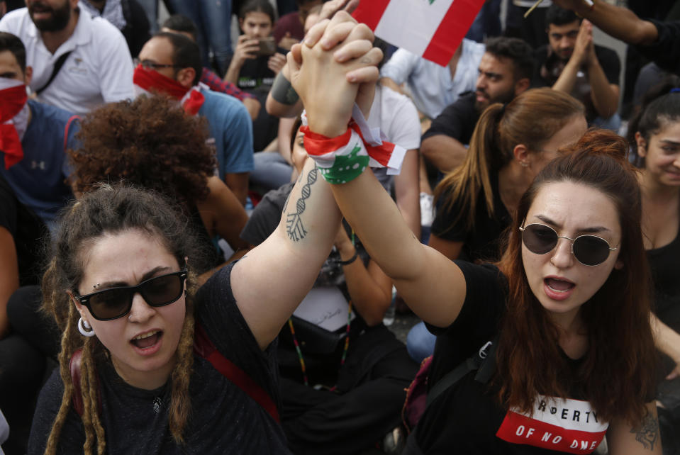 Anti-government protesters shout slogans as they block a main highway, in Beirut, Lebanon, Saturday, Oct. 26, 2019. Lebanese security forces pushed and dragged away protesters who refused to move from roadblocks in central Beirut on Saturday, to reopen roads closed during a campaign of civil disobedience. (AP Photo/Hussein Malla)