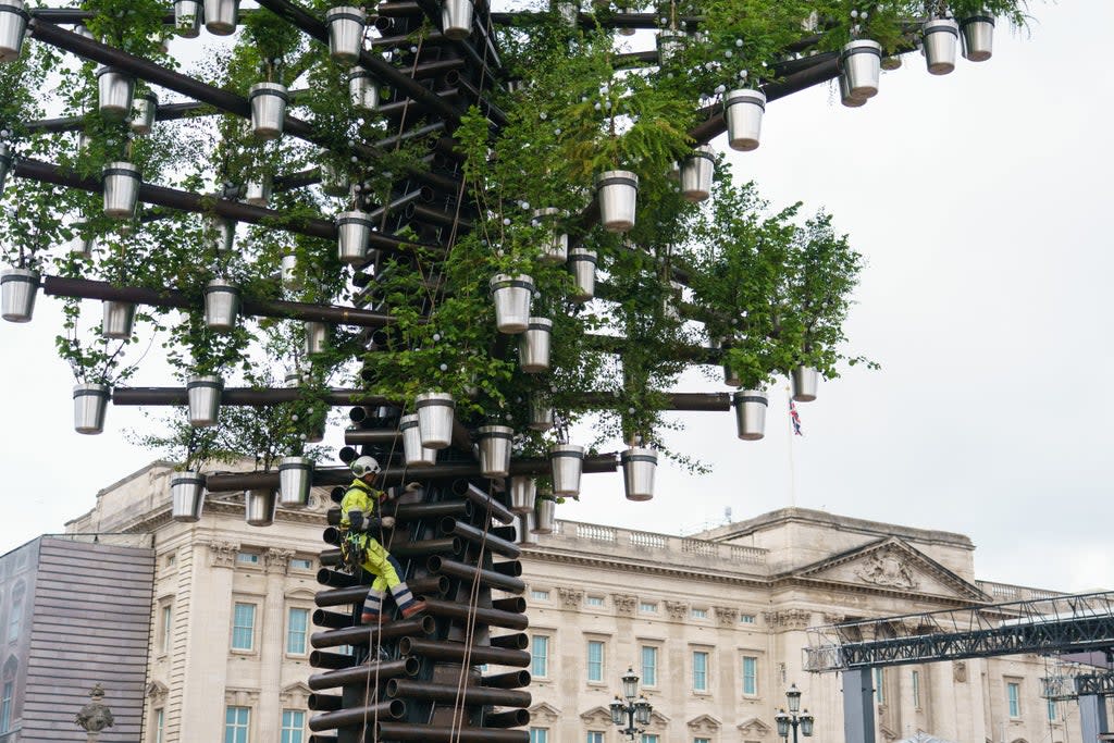 A construction worker climbs the Queen’s Green Canopy Tree Of Trees installation, designed by Thomas Heatherwick (Dominic Lipinski/PA) (PA Wire)