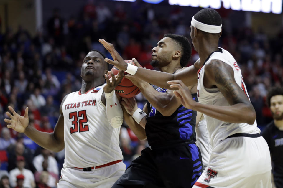 Buffalo's Jayvon Graves, center, heads to the basket as Texas Tech's Norense Odiase (32) and Tariq Owens defend during the second half of a second round men's college basketball game in the NCAA Tournament Sunday, March 24, 2019, in Tulsa, Okla. Texas Tech won 78-58. (AP Photo/Jeff Roberson)