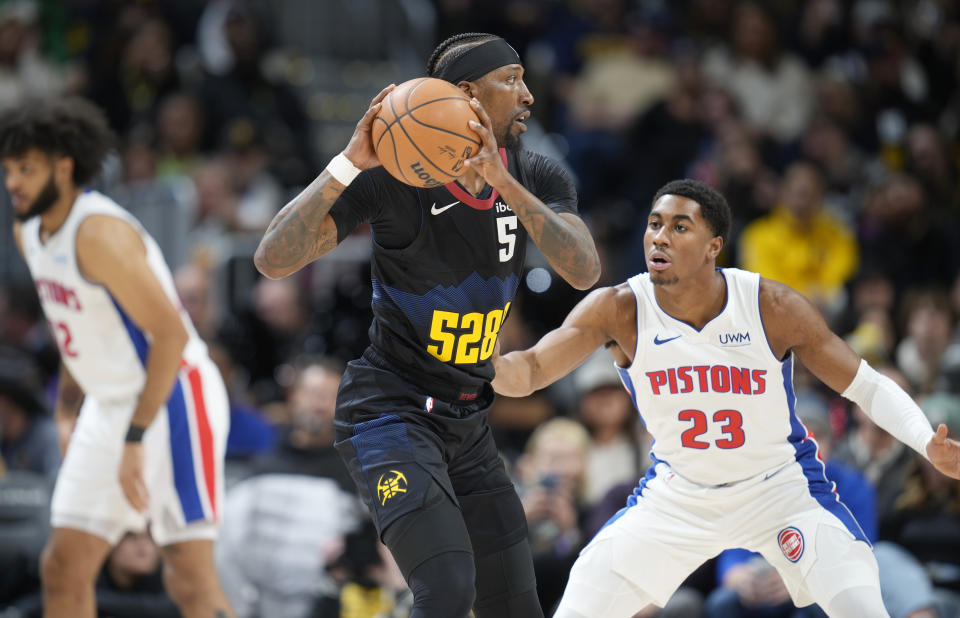 Denver Nuggets guard Kentavious Caldwell-Pope (5) looks to pass the ball as Detroit Pistons guard Jaden Ivey defends (23) in the second half of an NBA basketball game Sunday, Jan. 7, 2024, in Denver. (AP Photo/David Zalubowski)