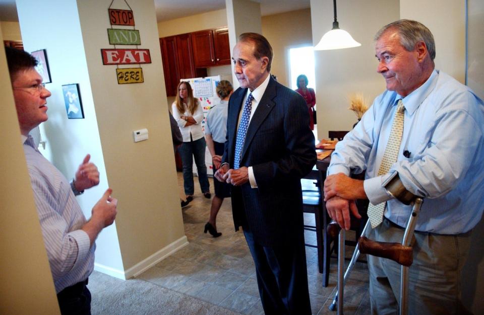 SSgt. Bryan McNees, left, talks with former Sen. Bob Dole, center, and Edward Eckenhoff in McNees' Fort Bragg home in July 2007. McNees was injured in Iraq and lived in ADA-compliant post housing. The President's Commission traveled to more than a dozen military and VA facilities across the country to hear first-hand how injured and wounded service members are navigating the health care system.