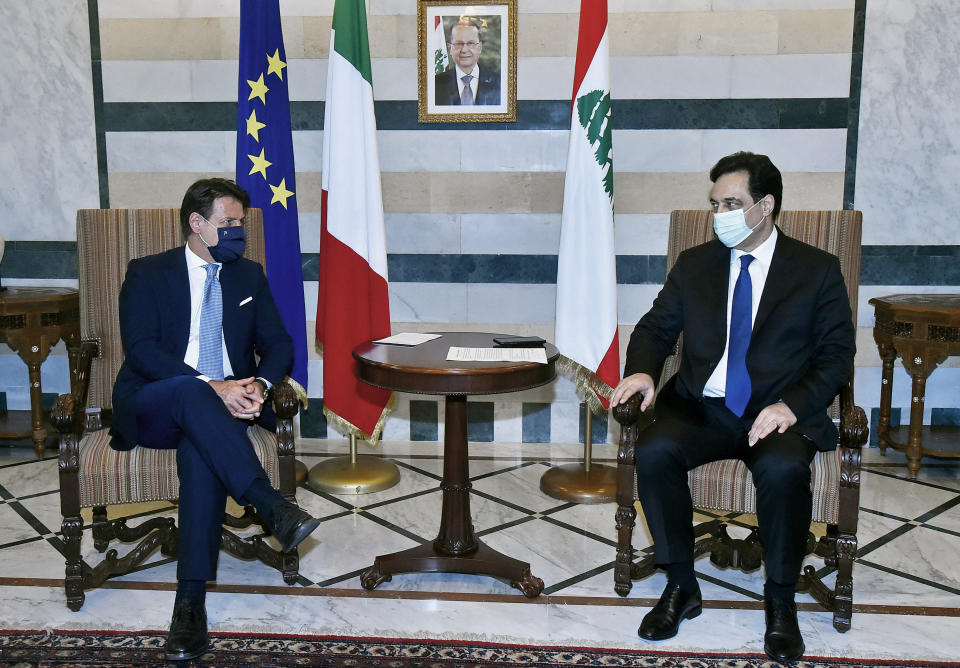 In this photo released by Lebanon's official government photographer Dalati Nohra, outgoing Lebanese Prime Minister Hassan Diab, right, meets with Italian Prime Minister Giuseppe Conte at the government palace, in Beirut, Lebanon, Tuesday, Sept. 8, 2020. Conte said Tuesday his country will support Lebanon's economic and social growth, expressing hopes that a new government is formed quickly — one that would start the reconstruction process in the wake of last month's Beirut explosion and implement badly needed reforms. (Dalati Nohra via AP)