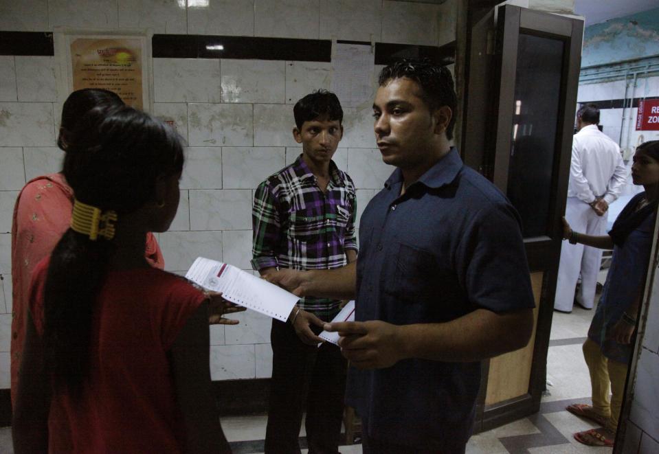 In this Thursday, July 26, 2012 photo, Amarjeet Singh, fourth left, gives directions to an incoming patient at the Deen Dayal Upadhyay Hospital in New Delhi, India. Singh and 20 other bouncers have been hired to protect doctors as well as keep the emergency and labor rooms from filling up with patients’ often agitated relatives and friends. (AP Photo/Nasr ul Hadi)