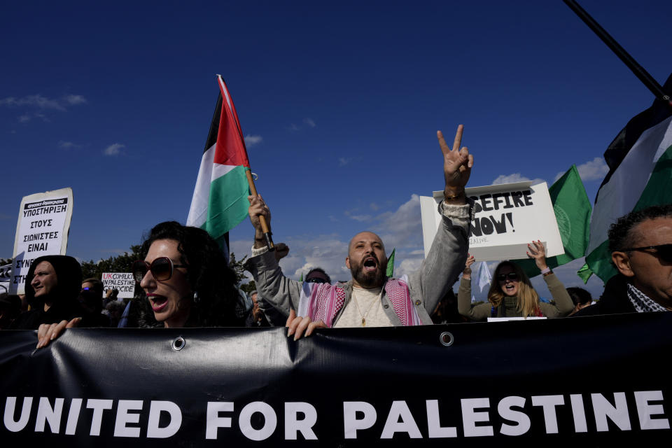 Demonstrators shout slogans and hold placards condemning Israel's military operations inside the Gaza strip, outside the entrance of RAF Akrotiri, near southern port city of Limassol, Cyprus, on Sunday, Jan. 14, 2024. Protest organizers said the protest also condemns what they call the "use of Cyprus as a launchpad for war" after British warplanes took off from RAF Akrotiri to bomb targets in Yemen following Houthi attacks on international shipping. (AP Photo/Petros Karadjias)