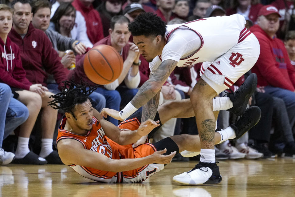 Illinois forward Ty Rodgers, left, and Indiana guard Jalen Hood-Schifino go for a loose ball in the second half of an NCAA college basketball game in Bloomington, Ind., Saturday, Feb. 18, 2023. Indiana defeated Illinois 71-68. (AP Photo/Michael Conroy)