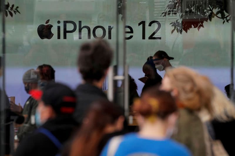 FILE PHOTO: Customers wait in line outside an Apple Store to pick up Apple's new 5G iPhone 12 in Brooklyn, New York
