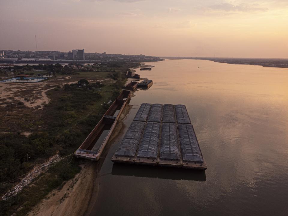 Barges wait to be transported amid an ongoing drought that is affecting the water levels of the Paraguay river in San Miguel bank beach, Paraguay, Monday, Sept. 20, 2021. AP Photo/Jorge Saenz)