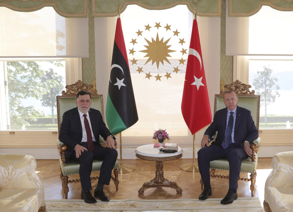 FILE - In this Saturday, July 25, 2020 file photo, Turkey's President Recep Tayyip Erdogan, right, and Fayez Sarraj, the head of Libya's internationally-recognized government, pose for photographs prior to their talks in Istanbul. Turkey is secretly expanding its footprint in conflict-ridden Libya, fueling the country’s civil war and deepening fault lines with Mediterranean neighbors and between international allies. Turkey seems to be after lucrative construction and port contracts, according to Libyan officials. (Turkish Presidency via AP, Pool, File)