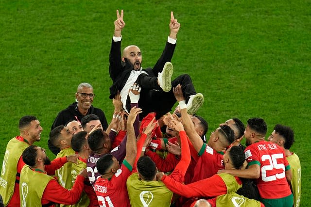 Morocco’s coach Walid Regragui is thrown in the air by his players