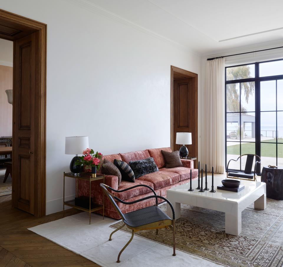 In the living room, vintage El Rey chairs by Mats Theselius flank a lacquered cocktail table by Karl Springer. Maison Jansen accent tables bookend a custom sofa by Jonas Upholstery and are topped with vintage ceramic lamps by Bergboms.