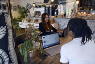 Sonya Barlow, left, CEO of Like Minded Females Network, speaks to Rebekah Ingram, her intern, at White Mulberries, a coffee shop in London, Thursday, Sep. 2, 2021. Many young workers around the world have entered the workforce and begun their careers during the pandemic working entirely remotely. Like Minded Females Network is a social enterprise that helps young women set up businesses and other ventures, without the use of a fixed office space. (AP Photo/Urooba Jamal)