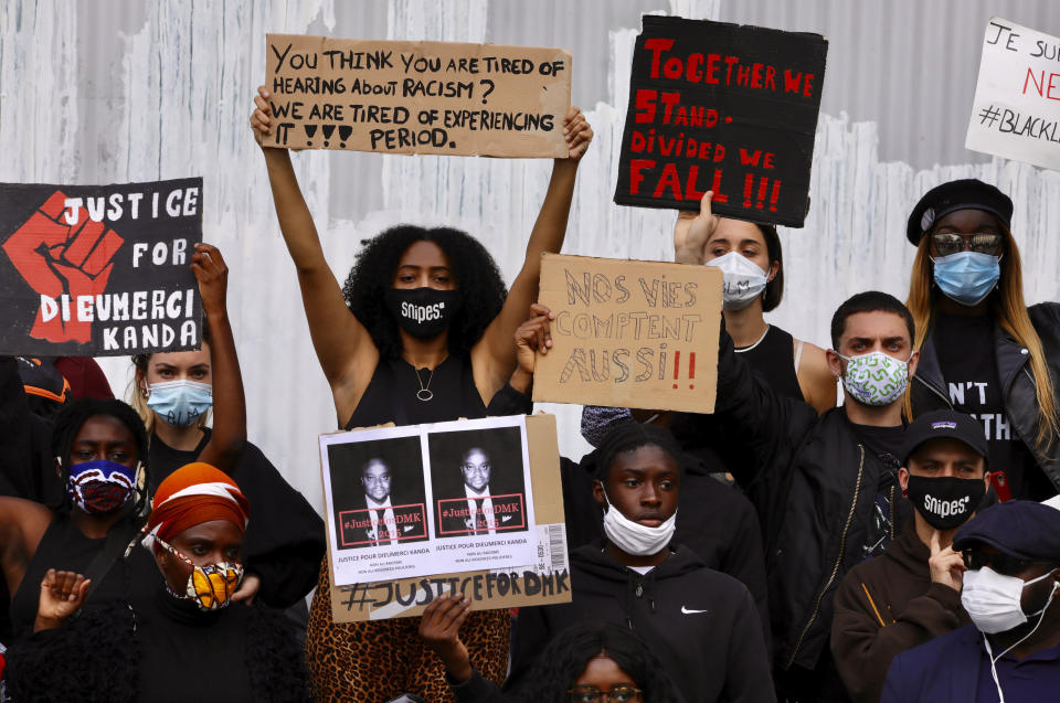 Protesters hold placards as they gather in central Brussels during the Black Lives Matter protest rally, Sunday, June 7, 2020. The demonstration was held in response to the recent killing of George Floyd by police officers in Minneapolis, USA, that has led to protests in many countries and across the US. Sign in center reads in French 'our lives count too'. (AP Photo/Olivier Matthys)