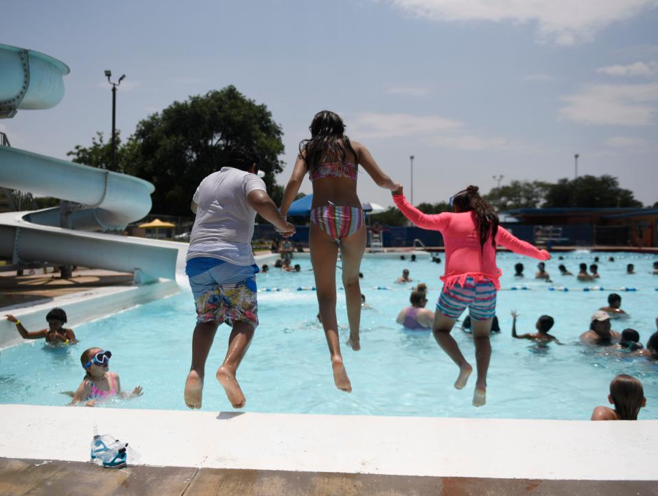 Eleven-year-old Everitt Martinez, 13-year-old Kry'stal Gamboa and nine-year-old Aubra Martinez jump into Clapp Park Pool, Friday, June 23, 2023.