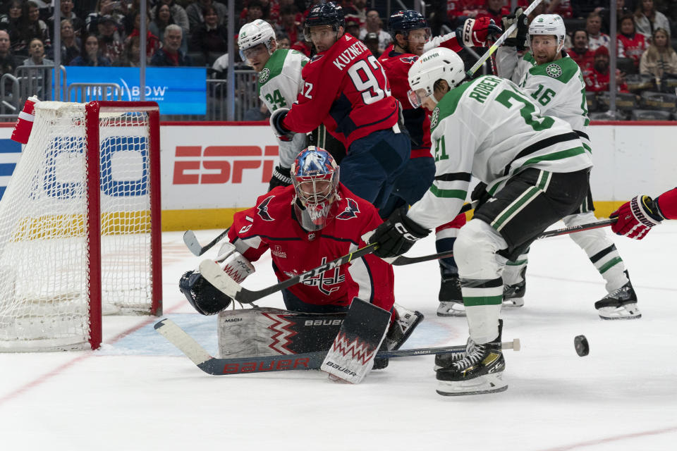 Washington Capitals goaltender Charlie Lindgren, front left, deflects a shot by Dallas Stars left wing Jason Robertson (21) during the second period of an NHL hockey game, Thursday, Dec. 7, 2023, in Washington. (AP Photo/Stephanie Scarbrough)