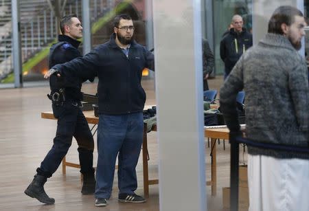 Bilal El Makhoukhi (2nd L) and Michael Delefortrie (R), who are suspected of being part of "Sharia4Belgium", pass the security check as they arrive for the verdict in the trial of the group in Antwerp February 11, 2015. REUTERS/Francois Lenoir