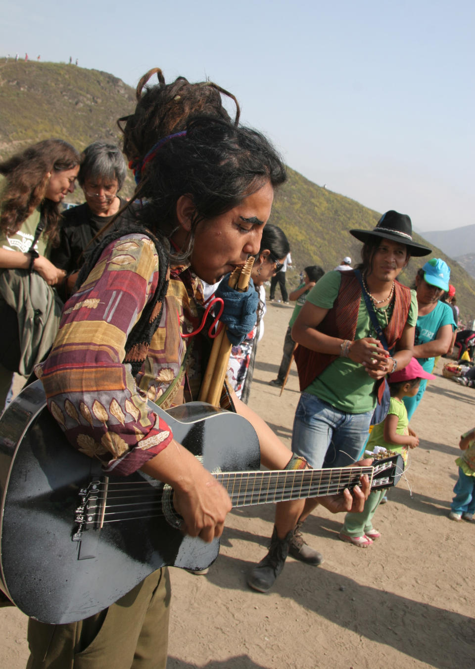 In this Nov. 1, 2012 photo, Luis Miguel Rogue plays a guitar and pan flute during the Day of the Dead festival at the Cemetery of Nueva Esperanza in Villa Maria del Triunfo in Lima, Peru. Rogue is part of the procession of Santa Muerte. (AP Photo/Jody Kurash)