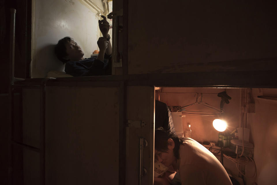 <p>Residents who only gave their surname Yeung, left, and Lui, rest in their “coffin homes” in Hong Kong, March 28, 2017. (Photo: Kin Cheung/AP) </p>