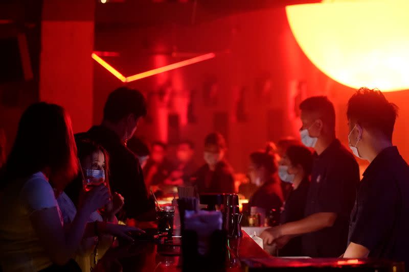 People wear face masks at a nightclub after it reopens in Shanghai