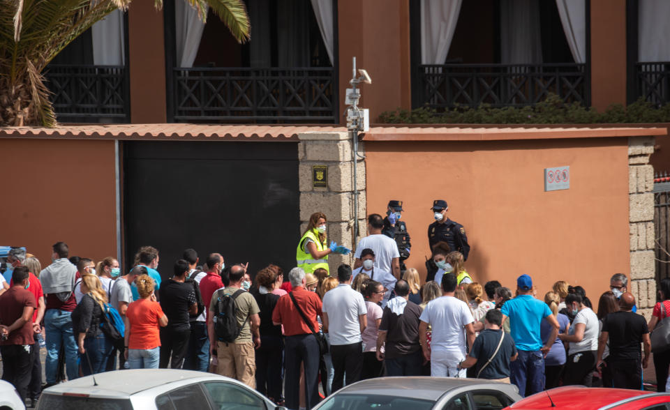 A psychologist talks to a group of workers outside the H10 Costa Adeje Palace Hotel in La Caleta, on February 25, 2020, where hundreds of people were confined after an Italian tourist was hospitalised with a suspected case of coronavirus. - Tourists staying in a four-star hotel on the Spanish island of Tenerife, in the Canary archipielago, were confined to their rooms today following the announcement of a suspected novel coronavirus, COVID-19, case waiting for official confirmation. This possible case was detected yesterday in Tenerife, where an Italian national passed a first test which turned out to be positive, announced the Spanish Ministry of Health. (Photo by DESIREE MARTIN / AFP) (Photo by DESIREE MARTIN/AFP via Getty Images)