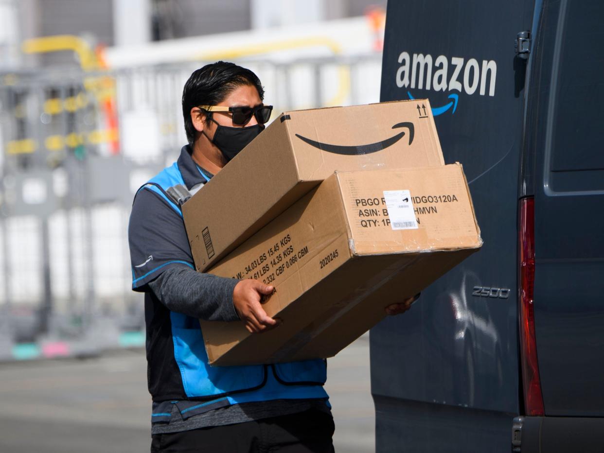 GettyImages 1230935623 An Amazon.com Inc. delivery driver carries boxes into a van outside of a distribution facility on February 2, 2021 in Hawthorne, California. - Jeff Bezos said February 1, 2021, he would give up his role as chief executive of Amazon later this year as the tech and e-commerce giant reported a surge in profit and revenue in the holiday quarter. The announcement came as Amazon reported a blowout holiday quarter with profits more than doubling to $7.2 billion and revenue jumping 44 percent to $125.6 billion. (Photo by Patrick T. FALLON / AFP) (Photo by PATRICK T. FALLON/AFP via Getty Images)