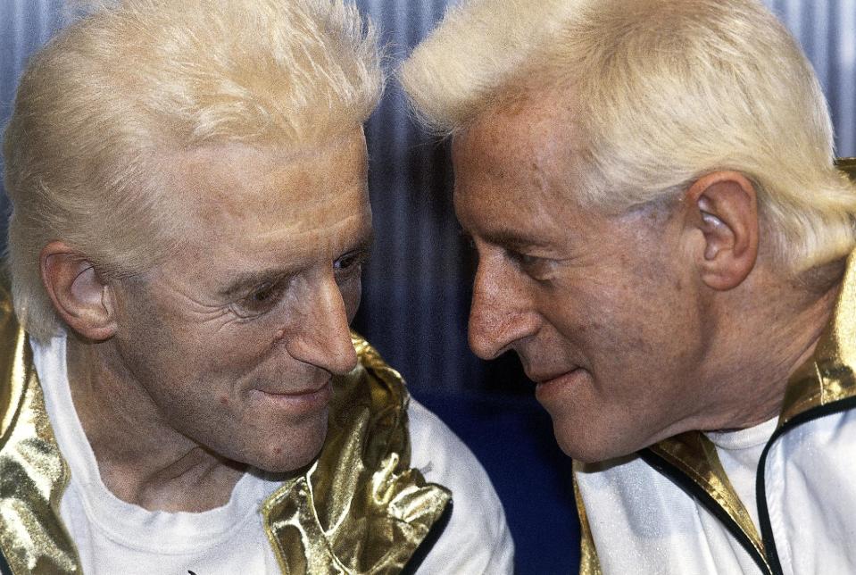 FILE - In this Dec. 17, 1986 file photo, Jimmy Savile, right, poses for photographers with a wax work model at Madame Tussauds museum in London. The BBC faced growing fallout Monday, Oct. 22, 2012 over sexual abuse allegations against Savile, as British Prime Minister David Cameron accused the broadcaster of changing its story about why it killed a news segment on the accusations. (AP Photo/John Redman, File)