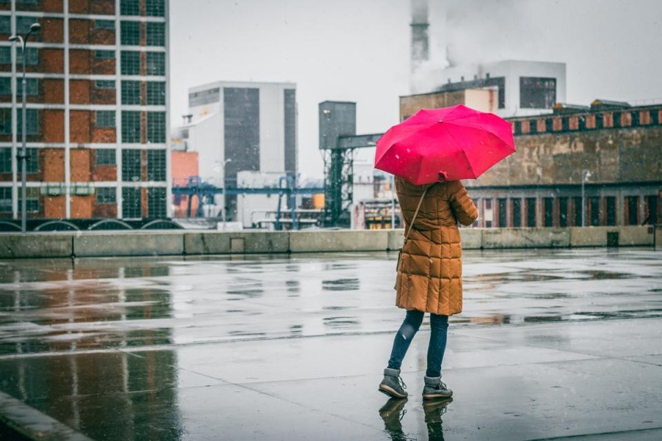 woman with red umbrella standing outside in the rain