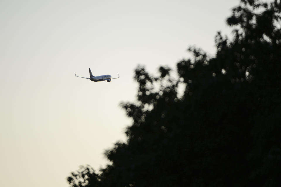 A Ryanair plane flies in the sky after taking off from Budapest Airport, in Budapest, Hungary, Sunday, June 12, 2022. Hungary has placed price caps on fuel and some food and imposed special taxes on industries as the government tries to ease an economic downturn and the highest inflation in nearly 25 years. (AP Photo/Anna Szilagyi)