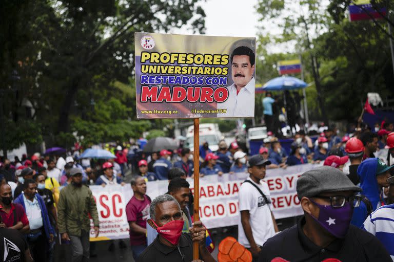 Un maestro sostiene un cartel durante una protesta de trabajadores públicos que exigen que el gobierno pague todos sus beneficios y respete los convenios colectivos en Caracas, Venezuela, el miércoles, 10 de agosto de 2022. 