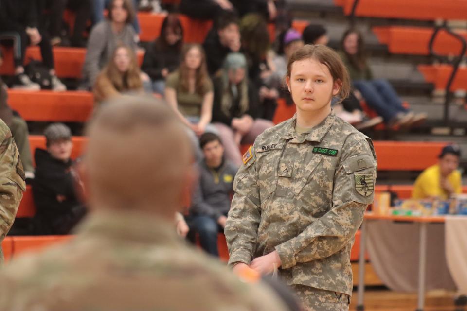 Chase Rubley, a Tecumseh High School sophomore and a member of the school's Cadet Corps, listens as Sgt. Maj. Dave Lewis answers his question during an assembly Friday, March 24, 2023, at Tecumseh High School with the Michigan Army National Guard and University of Michigan student-athletes.