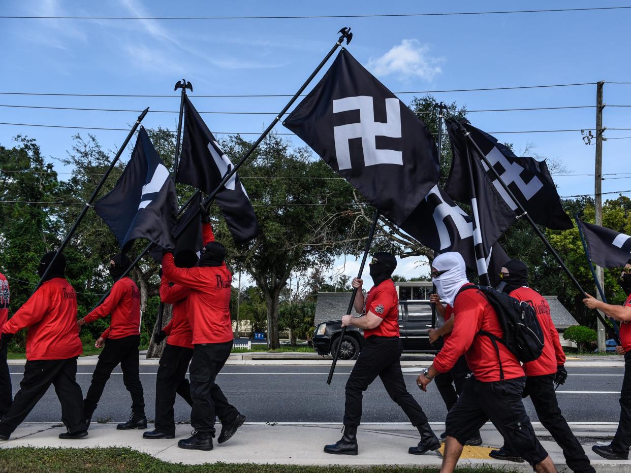 People hold swastika flags as neo-Nazi groups Blood Tribe, and Goyim Defense League hold a rally on September 2, 2023 in Orlando, Florida.