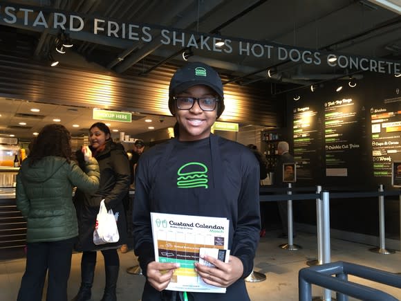 An employee greeting guests at a Shake Shack in Boston.