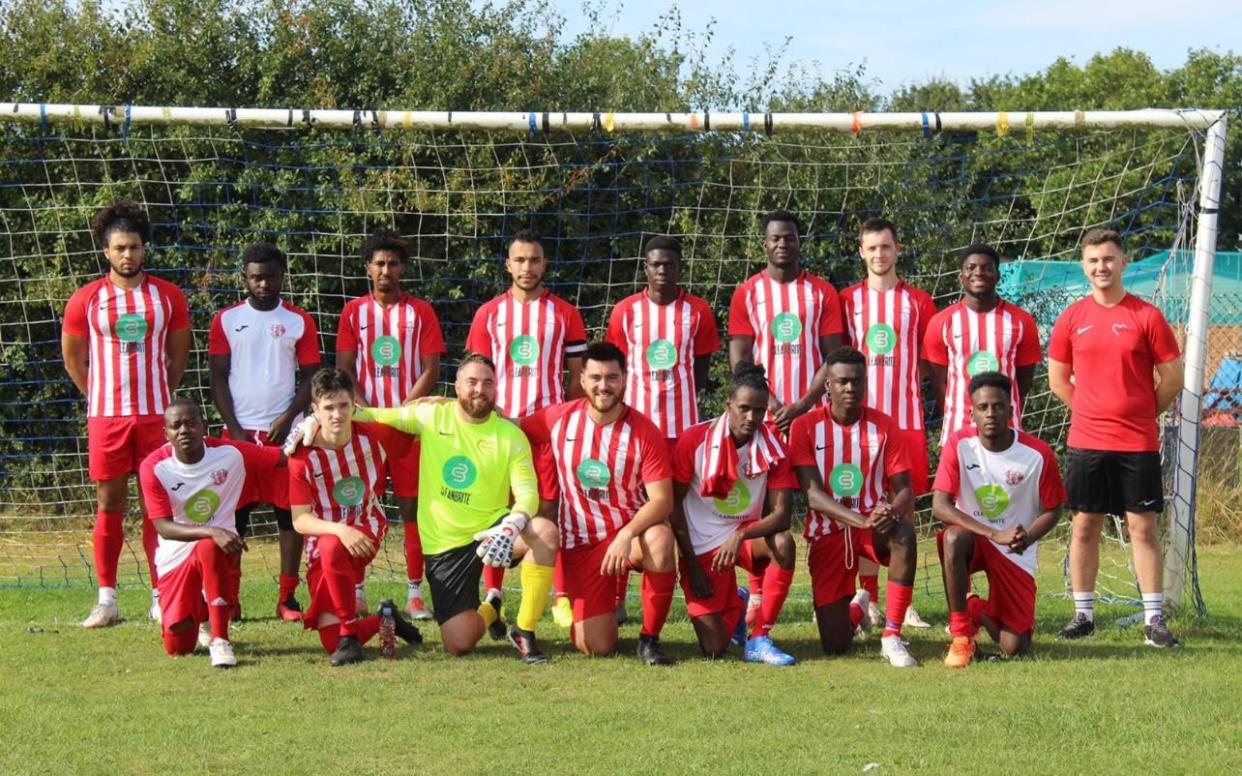 Football team standing in front of a football net