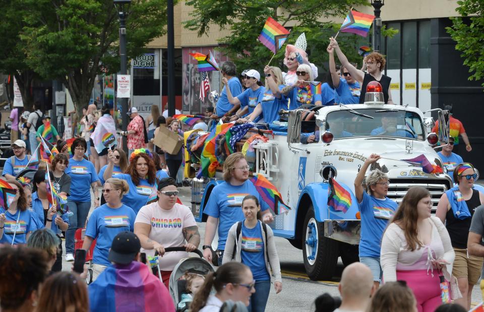People ride the Erie Insurance antique fire engine during the Erie Pride Parade in Erie on June 24, 2023. Thousands turned out for the parade and subsequent Pridefest events as State Street was closed from 12th Street to North Park Row. 