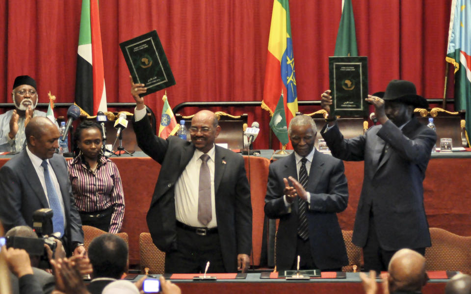 Sudan's President Omar al-Bashir, center-left, and South Sudan President Salva Kiir, right, gesture to celebrate the completion of a signing ceremony after the two countries reached a deal on economic and security agreements Thursday, Sept. 27, 2012 in Addis Ababa, Ethiopia. The presidents of Sudan and South Sudan signed agreements Thursday that will allow a resumption of oil exports from South Sudan, a demilitarized zone between their borders, and a cessation of all hostilities that brought the countries to the brink of all-out war just a few months ago. (AP Photo/Elias Asmare)